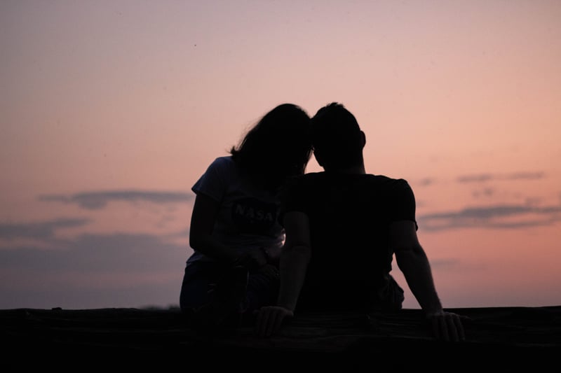 情侶坐著看夕陽。