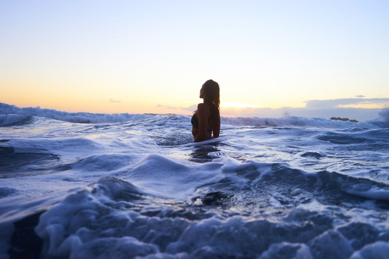 女生在海邊玩水。
