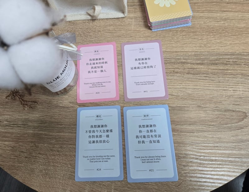 《謝謝你是你》牌卡擺在木桌上,卡面寫著我想謝謝你